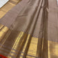 Smoky Taupe Butta saree with broad gold zari border and narrow Burnt Orange selvedge.