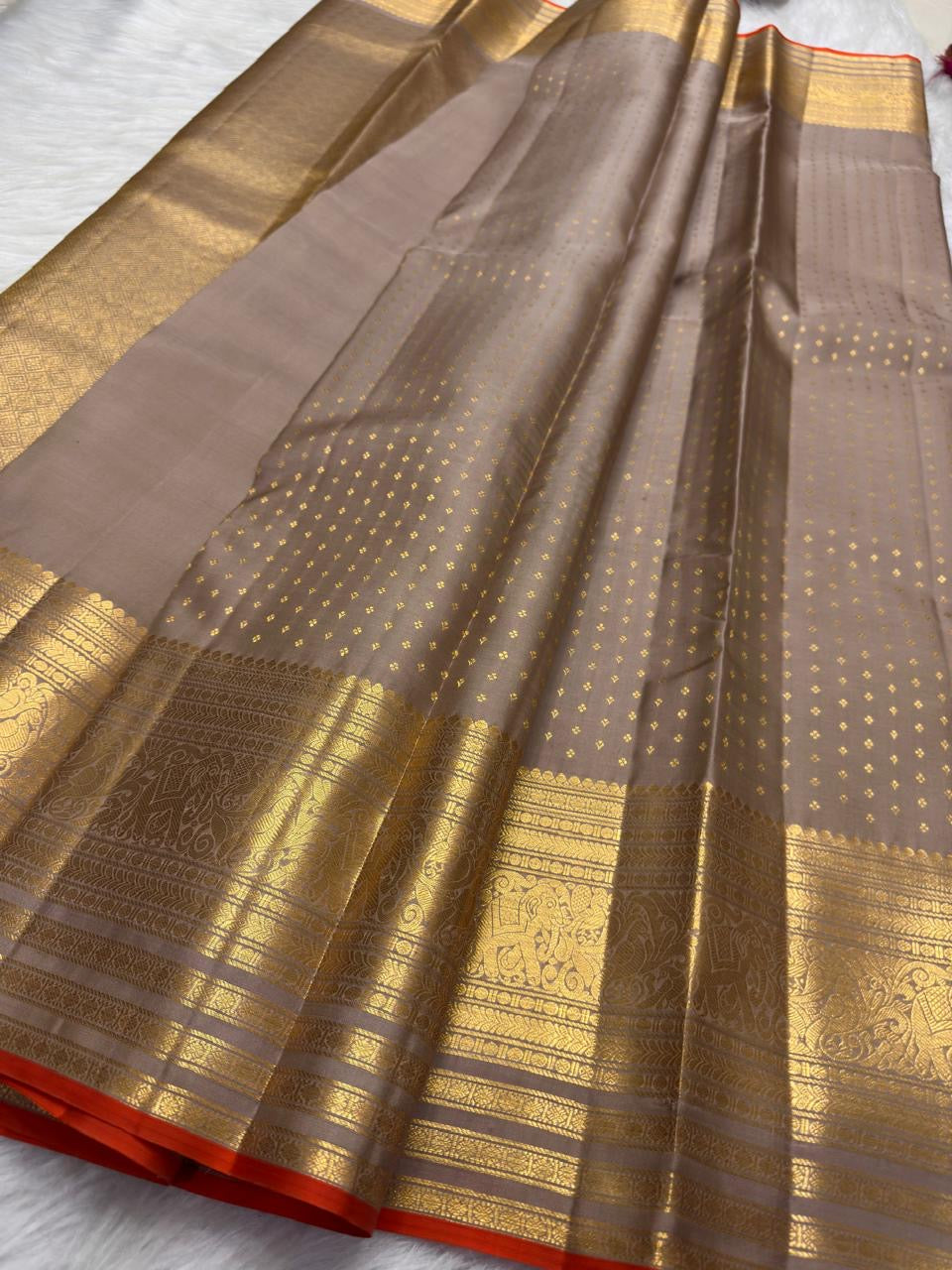 Smoky Taupe Butta saree with broad gold zari border and narrow Burnt Orange selvedge.