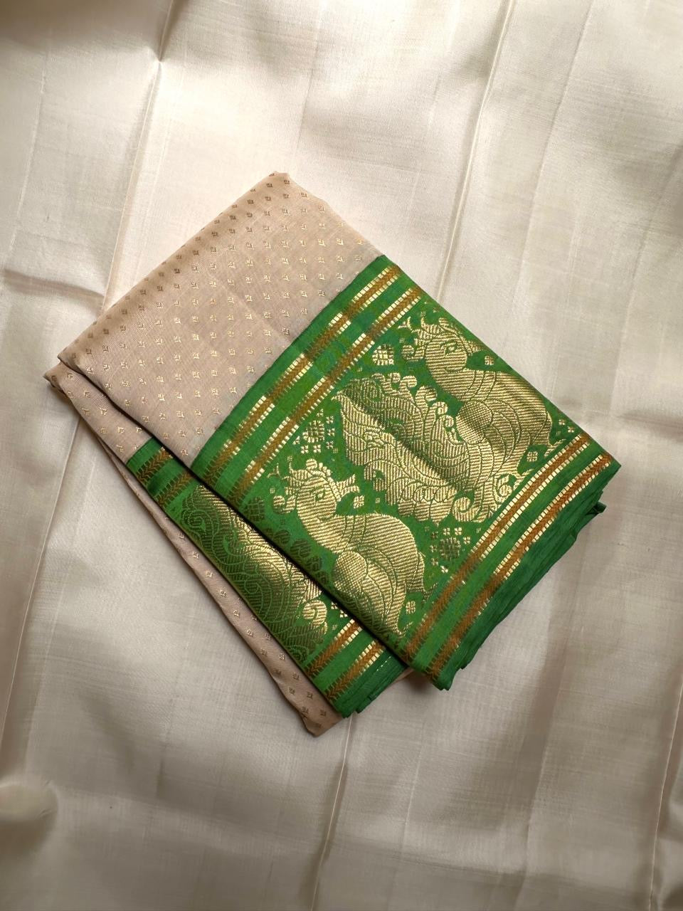 Soft ivory handwoven pure silk Kanjipuram saree with emerald green Korvai peacock border, full view
