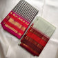 Warm gold zari border bands against the vivid red-pink edge of the saree.