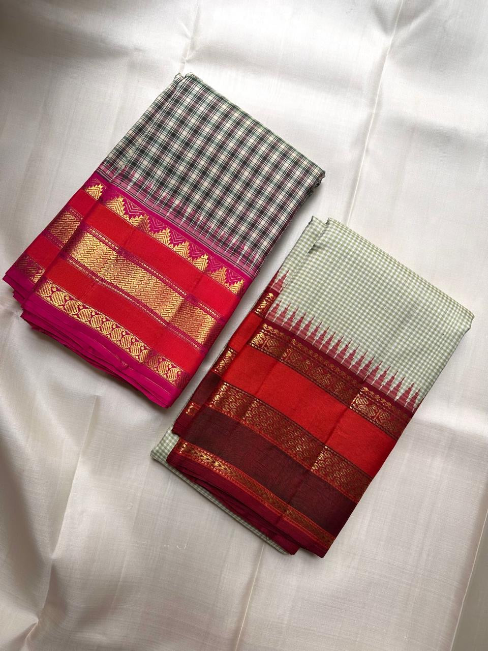 Warm gold zari border bands against the vivid red-pink edge of the saree.