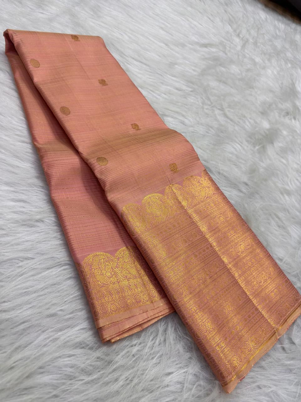 Soft Peach Blush Zari Kattam saree opened to show gold buttas, fine zari lines and tasselled pallu.