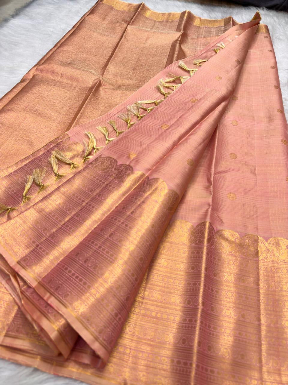 Close view of Soft Peach Blush Kanchipuram silk with fine gold Kattam structure and multi-register zari border.