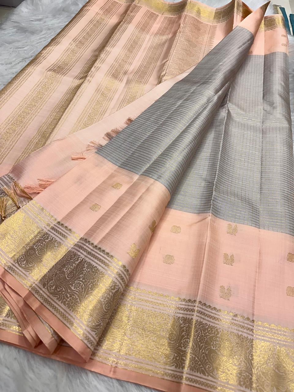 Soft Peach Pink and Silver Grey pure silk Kanjivaram Butta saree with antique-gold border.