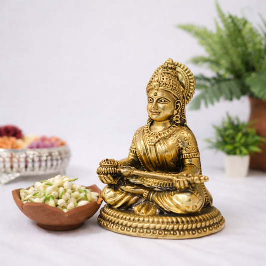 Pure brass Saraswati idol with veena in antique gold finish, intricately carved seated goddess statue for home temple decor