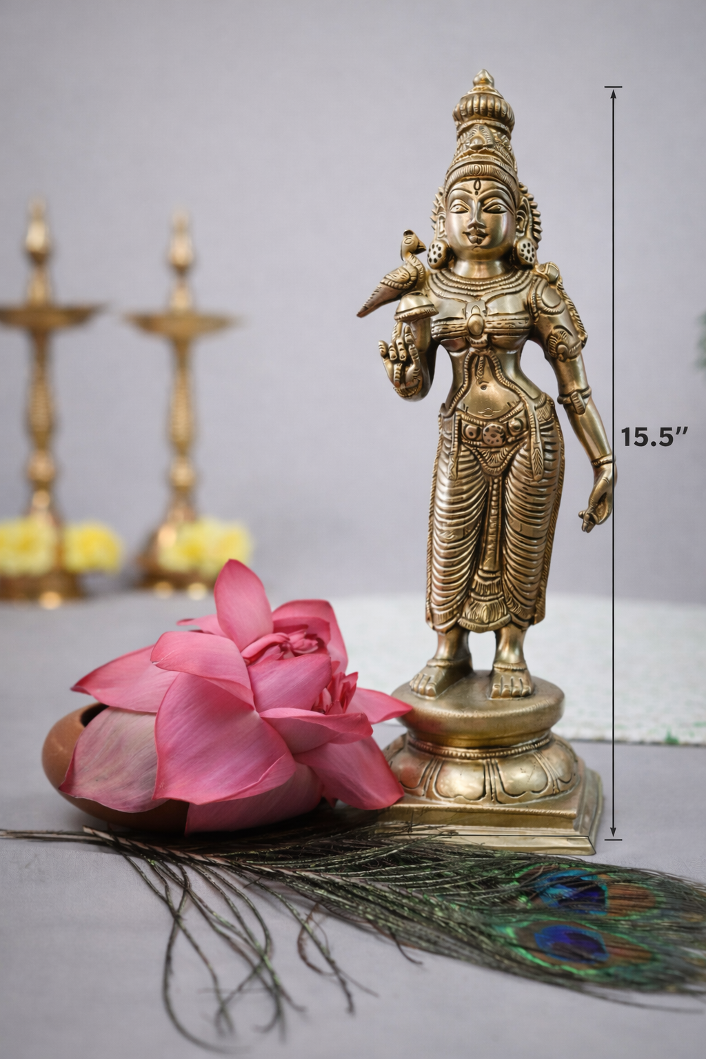 Side angle of solid brass Madurai Meenakshi idol showing intricate jewelry detailing and pedestal base