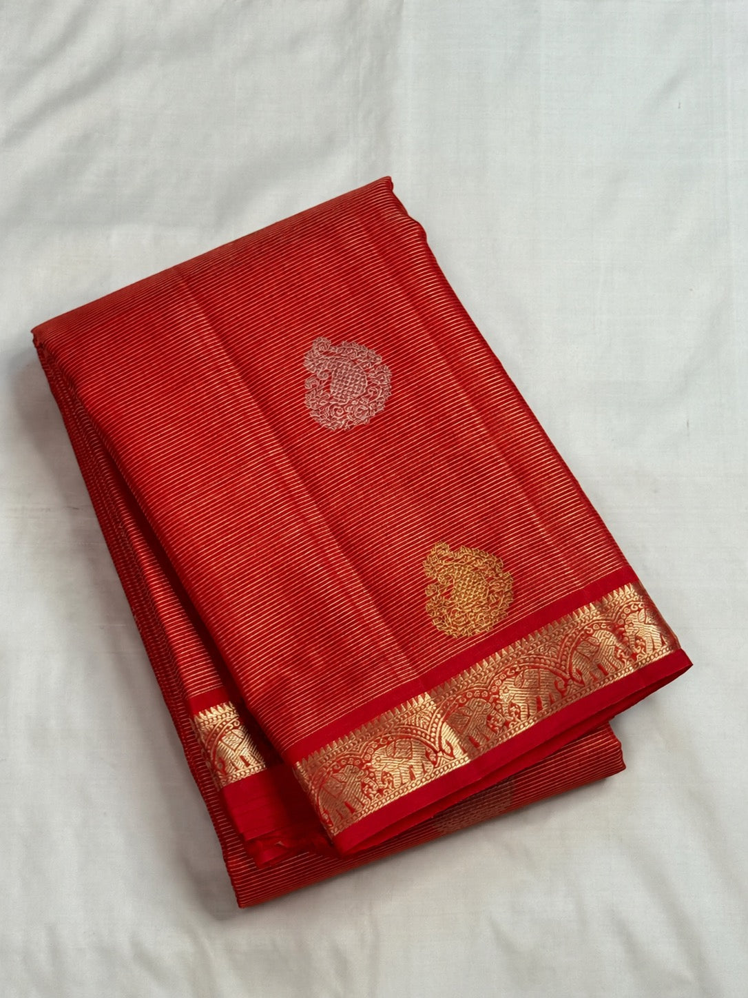 Gold and silver-toned Sona Rupa maanga paisley buttas spaced across red handwoven silk