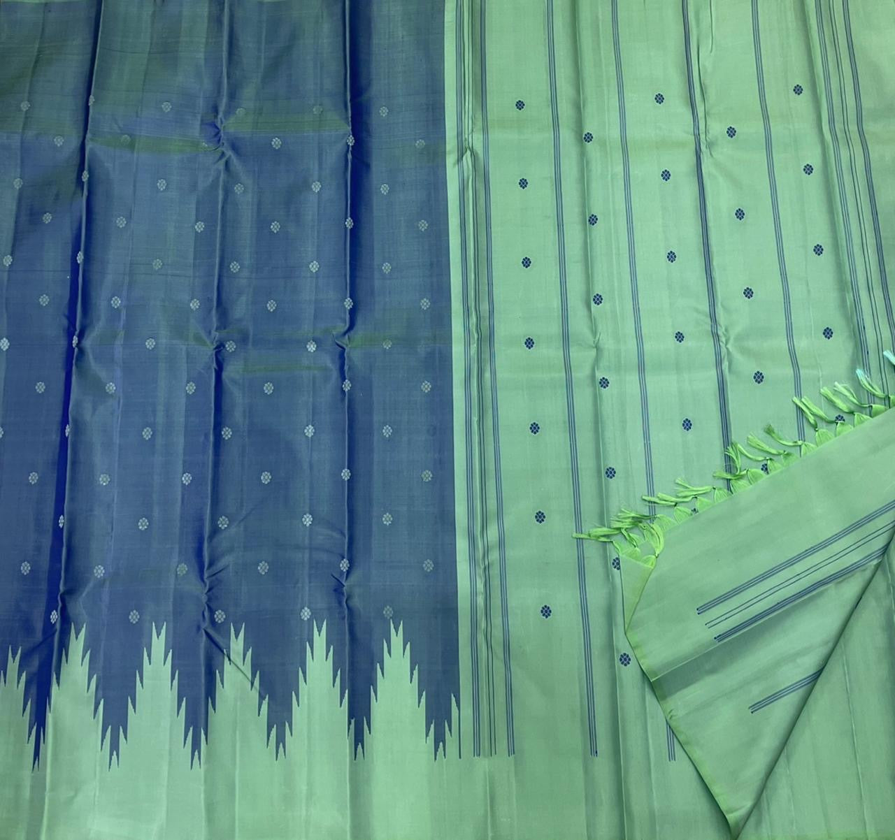 Folded deep blue Pure Kanchipuram silk saree with mint thazampoo reku contrast panel on white backdrop