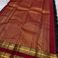 Draped view of black checked Kanchipuram silk saree with antique gold zari motifs, maroon pallu, and woven border