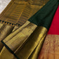 Close-up of gold zari woven border with deep green edging beside the red saree body on a light fabric background.
