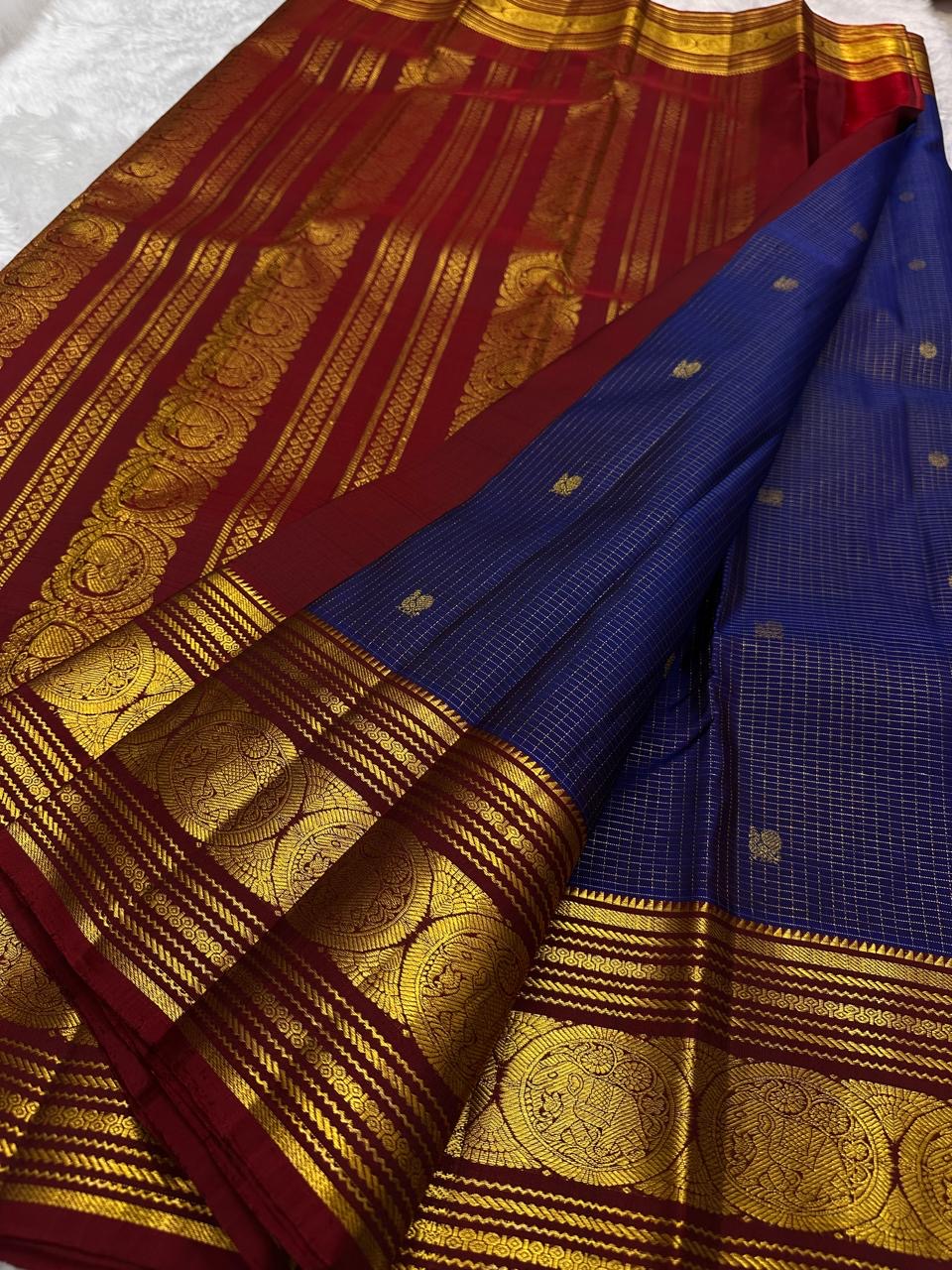 maroon zari woven border closeup with large circular elephant medallions on kanchipuram silk saree