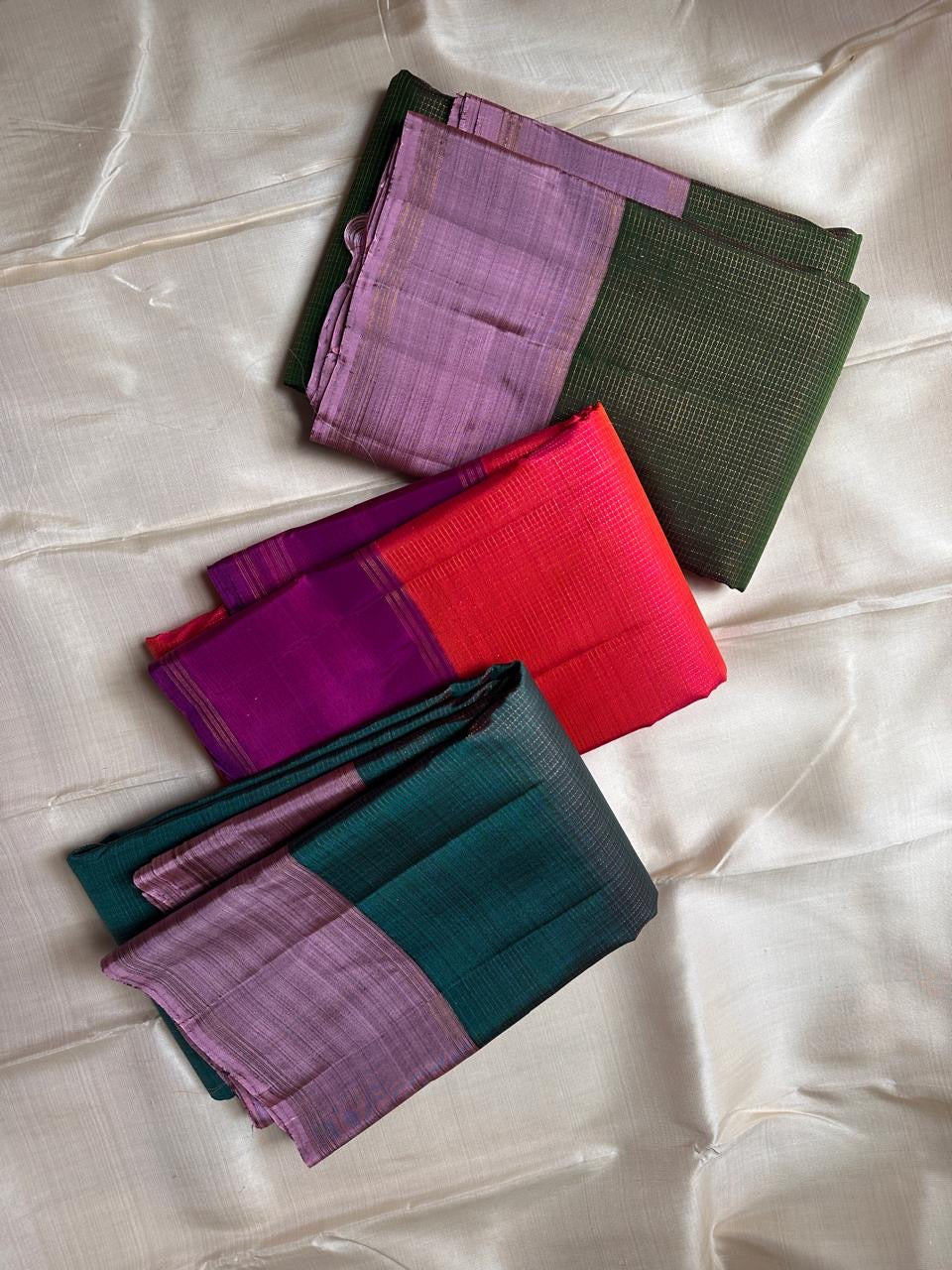 stacked folded silk sarees showing coral red pink and purple contrast pure kanchipuram silk saree