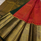 Partially draped Pure Kanchipuram silk saree with red body, deep green section, and wide gold zari woven border panels.