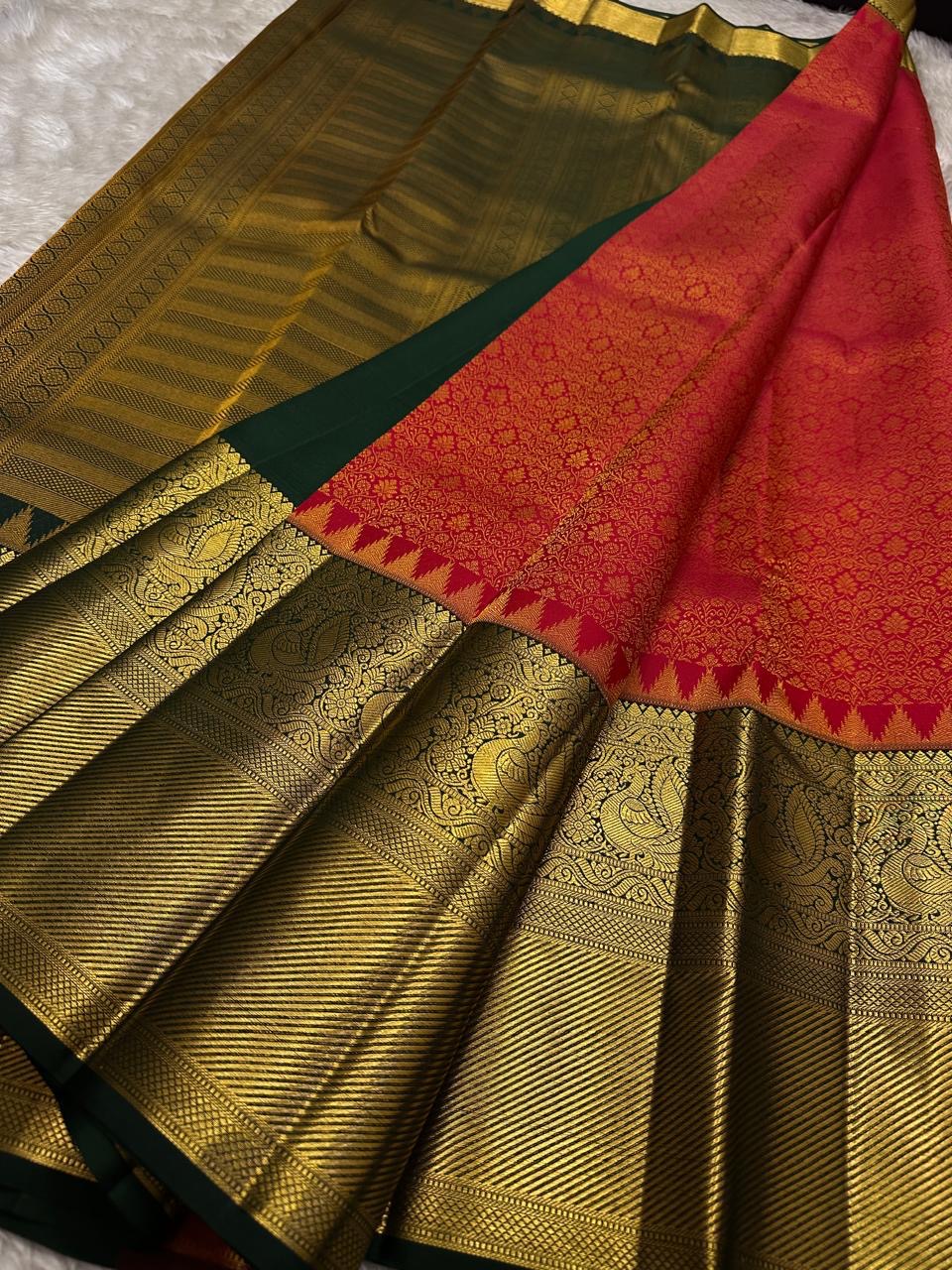 Partially draped Pure Kanchipuram silk saree with red body, deep green section, and wide gold zari woven border panels.