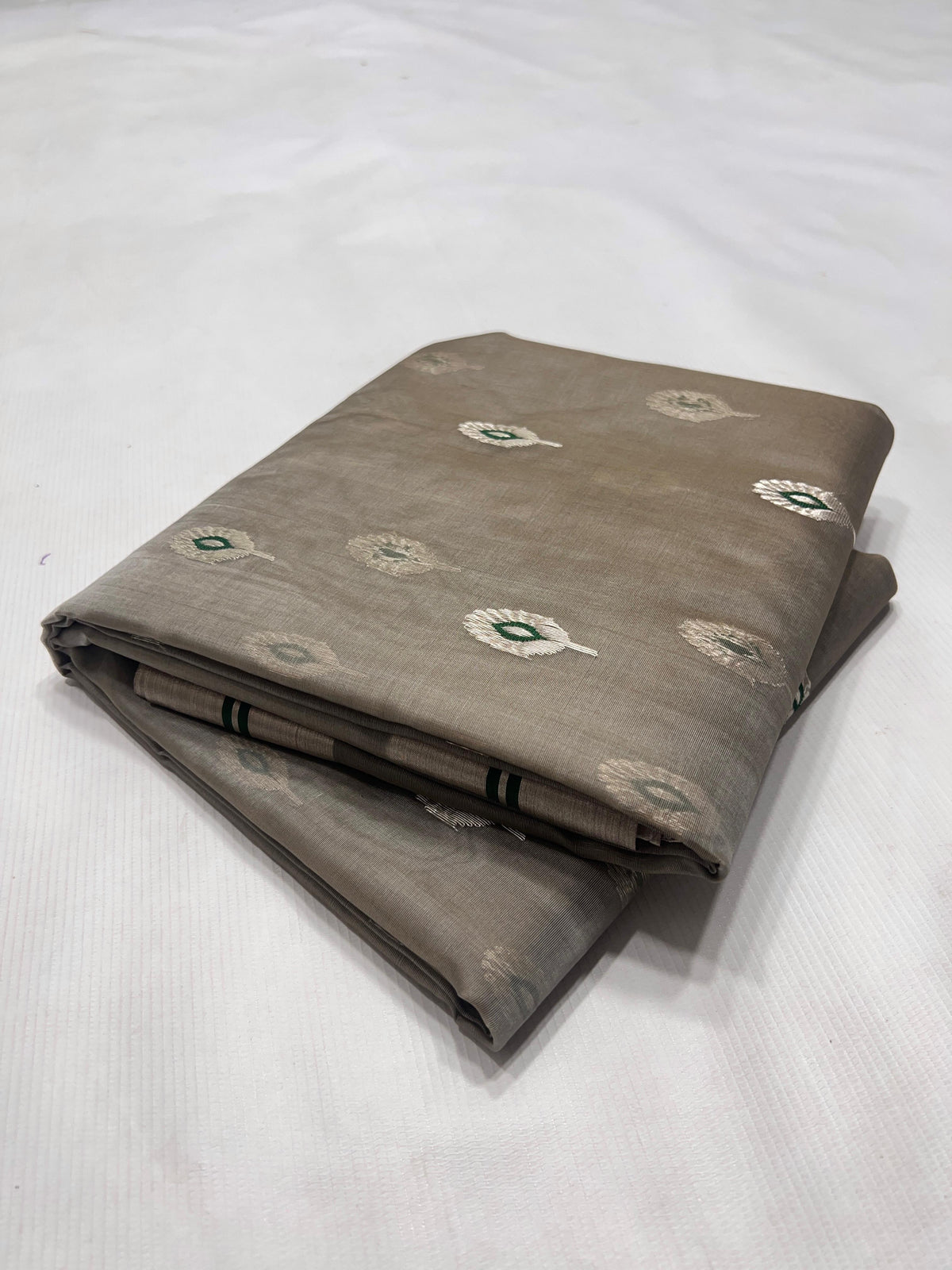 Stone Grey Katan Silk Chanderi saree with scattered silver feather motifs, emerald-green accents and broad silver border.