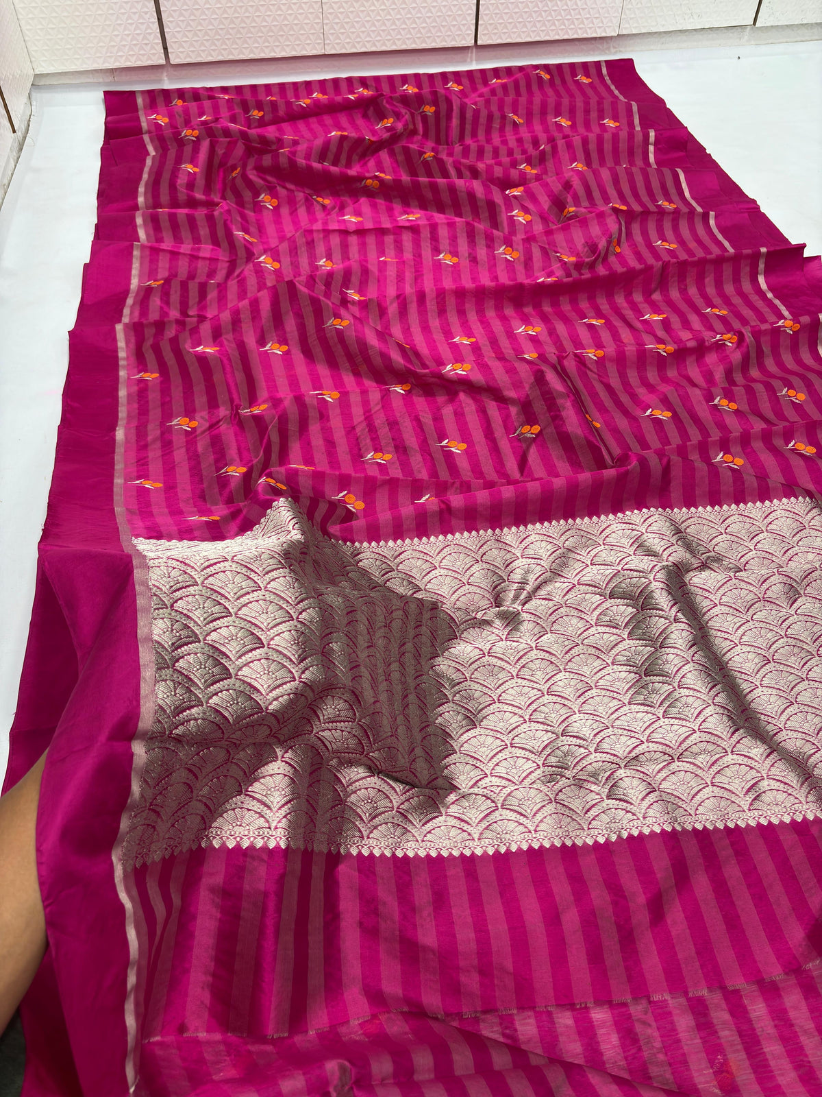 Raspberry Pink Pattu Silk Chanderi saree showing the fine metallic weaving of the striped body and pallu.