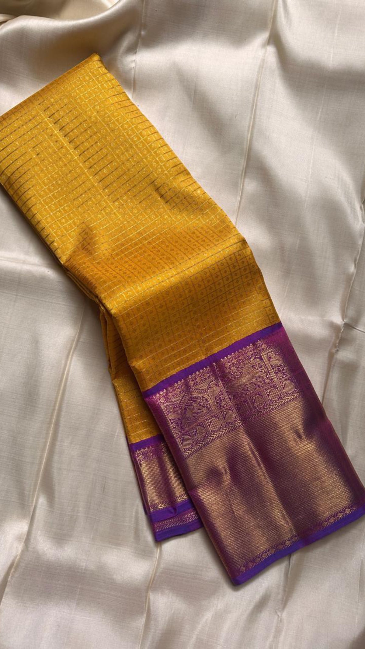 Blouse piece carrying the same broad purple border on sunflower yellow Kanjivaram saree