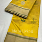 Spread-out view of sunflower yellow Chanderi silk saree showing evenly spaced white floral buttas and gold zari borders on both sides.