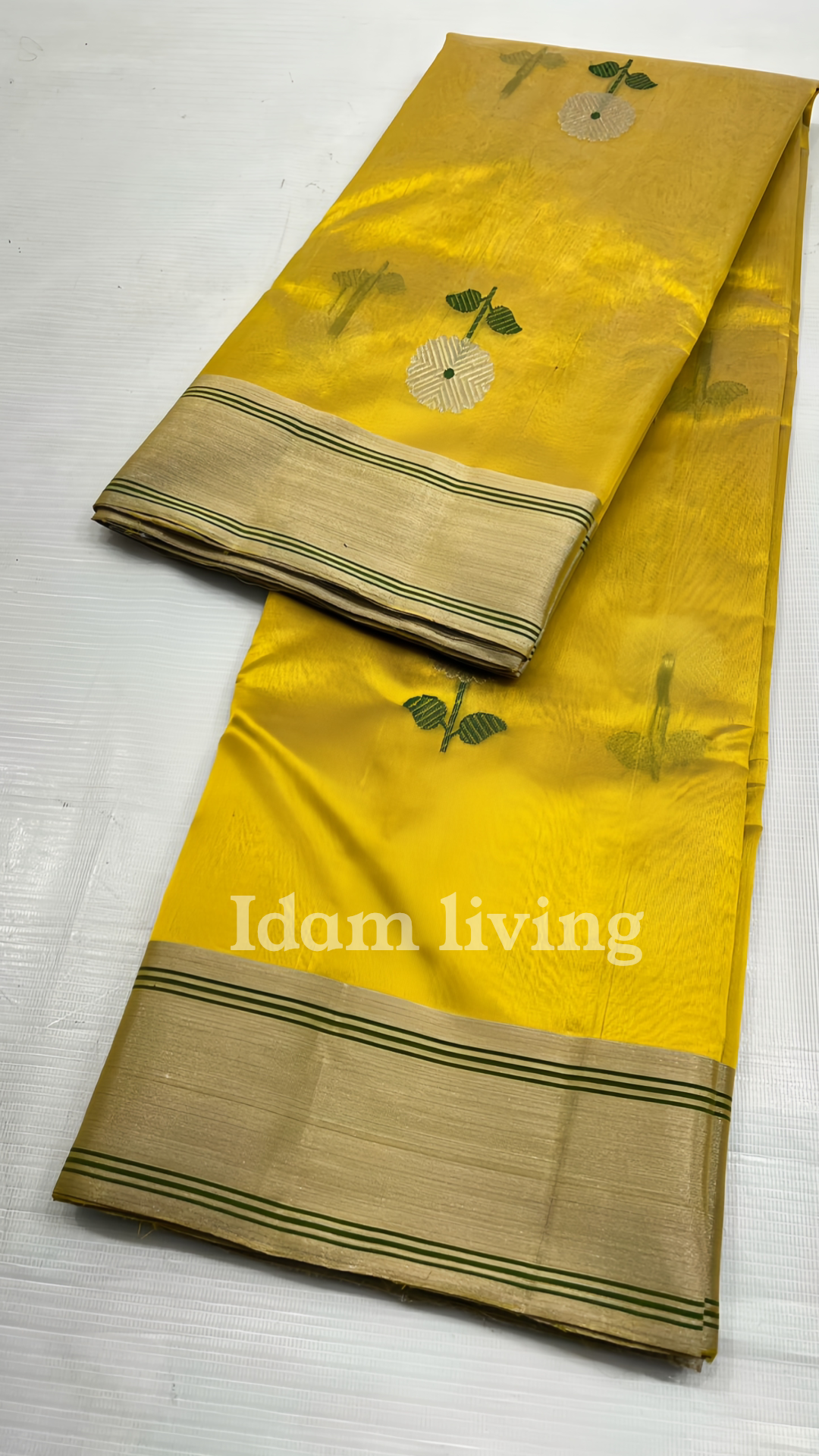 Spread-out view of sunflower yellow Chanderi silk saree showing evenly spaced white floral buttas and gold zari borders on both sides.