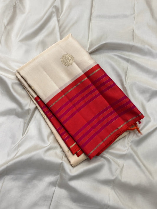 Warm ivory Pure Silk Kanchipuram saree with coral orange border and elegant zari body motifs