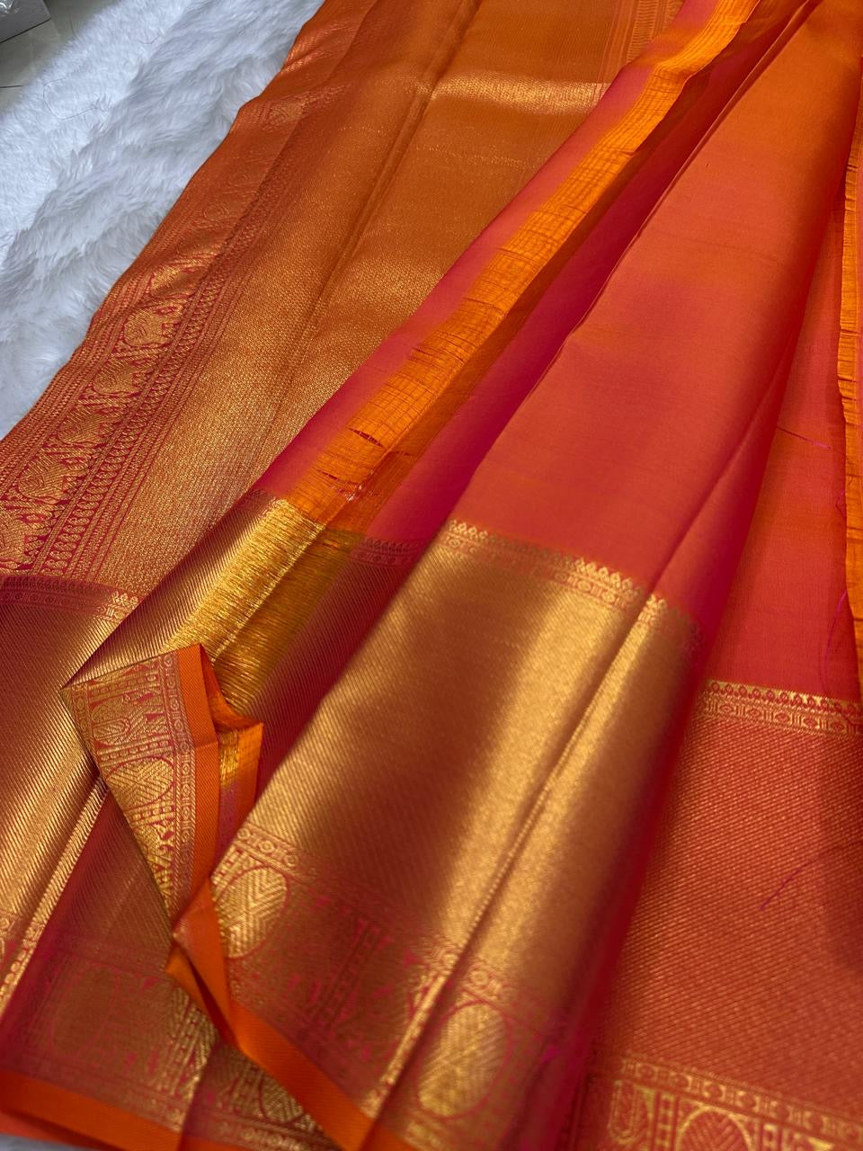 Sunset orange vermillion Kancheepuram saree, vermilion zari border with floral vines close-up