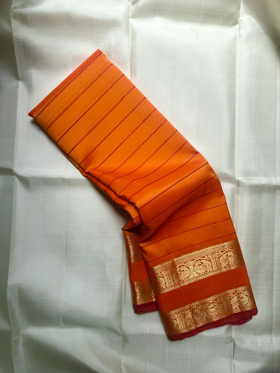 Kanchipattu silk saree in sunset orange with reddish pink border Veldhari Rettapet weave traditional zari detail