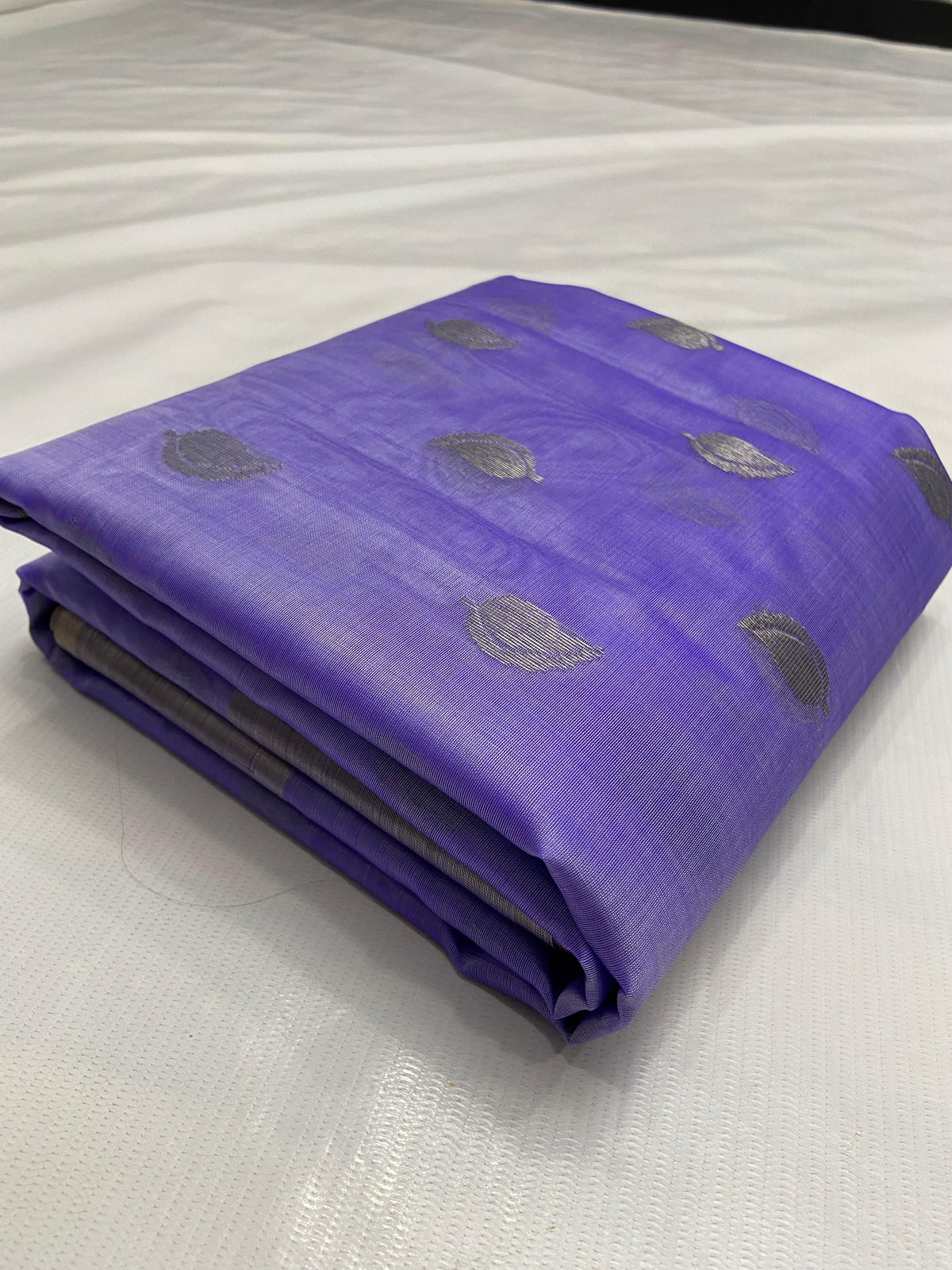 Folded amethyst lavender Pattu silk Chanderi saree showing silver-toned paisley buttas and silver-grey border