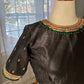 Flat lay of black silk cotton Tanjore designer blouse with intricate kemp embroidery