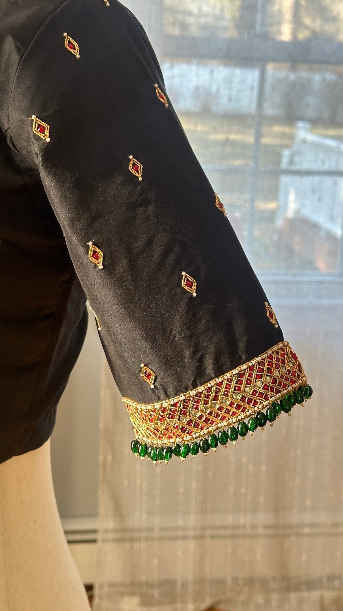 Detail view showing premium silk cotton fabric and temple jewelry-inspired embroidery on black blouse