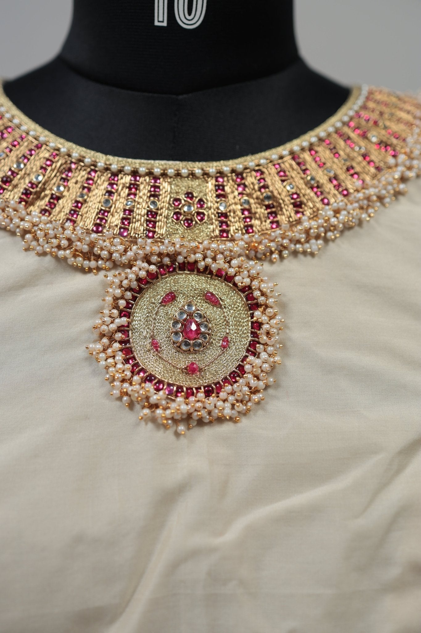 Detail view of cream silk blouse showing hand embroidery and long-lasting kemp stones