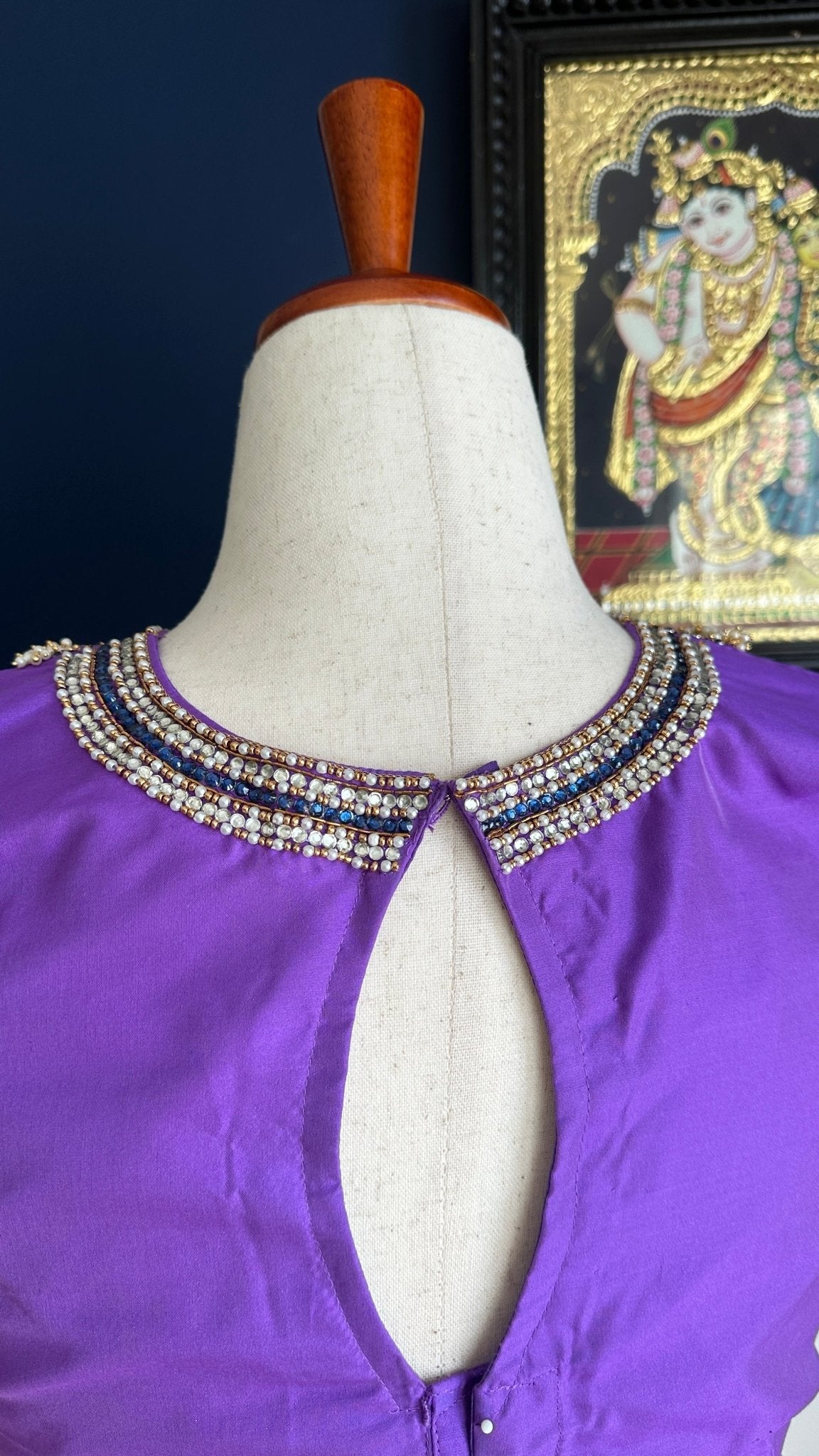 Purple silk Tanjore Treasure blouse with gold embroidery displayed on a hanger
