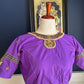 Purple silk designer blouse with gold kemp embroidery photographed against a white curtain