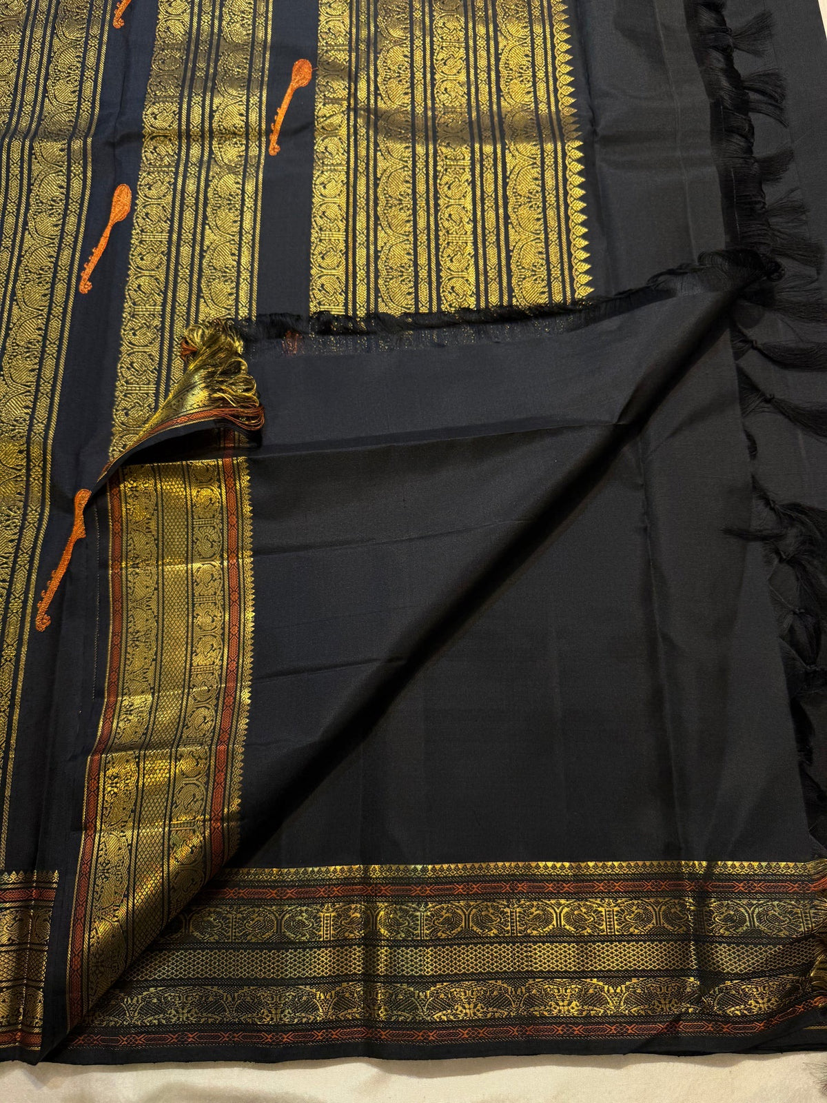 Black pallu with dense vertical gold-zari panels and tanpura woven silk-thread buttas.