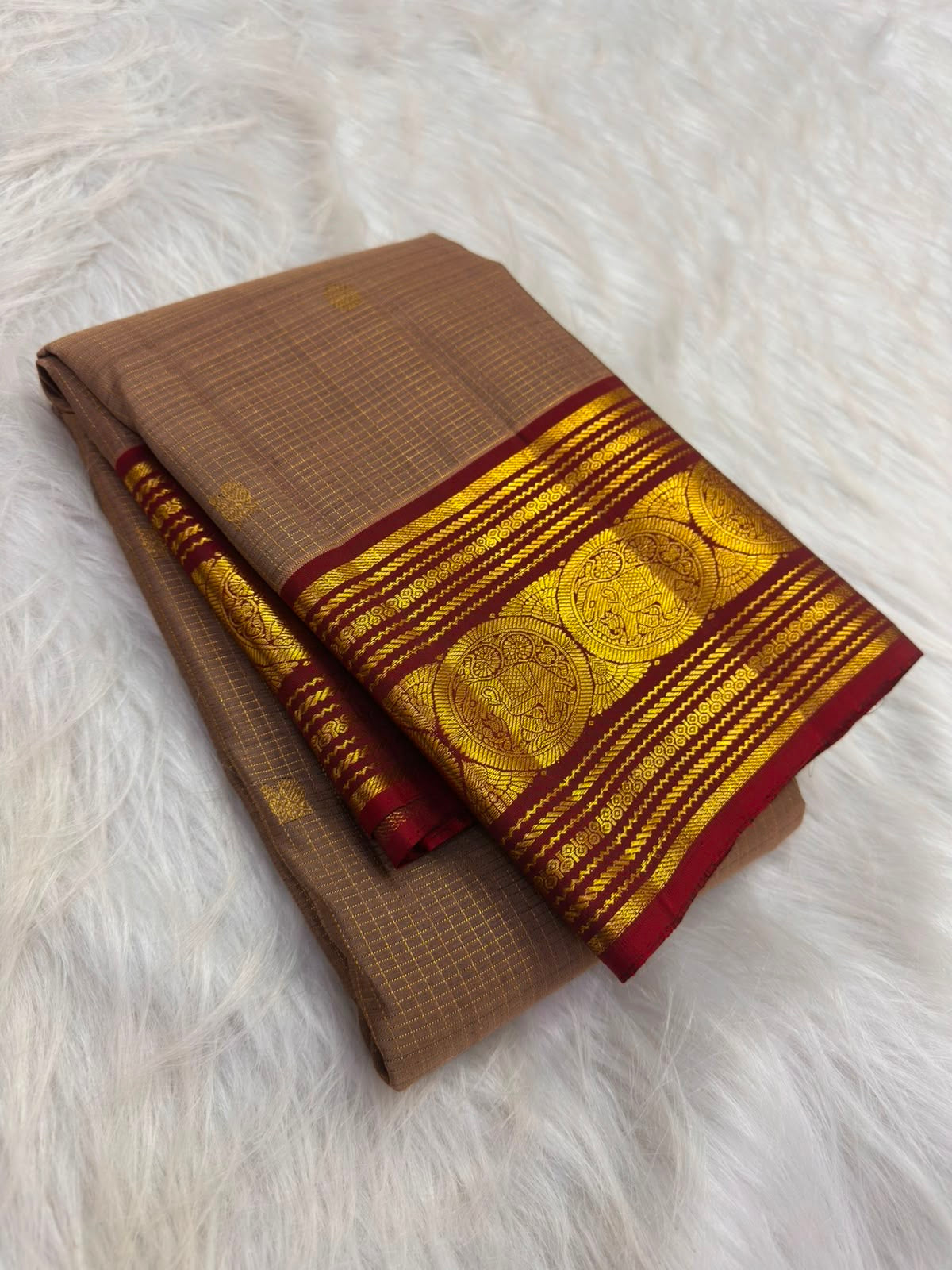Chandanam (sandalwood) handwoven Pure Silk Kanchipuram saree folded to show the ruby red border