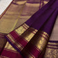 Smoky brown pure mulberry silk saree with small spaced zari motifs and traditional purple gold border.