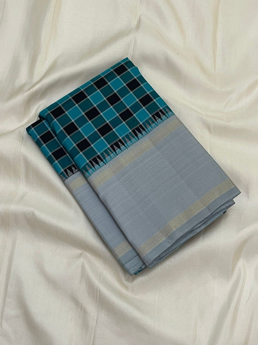 Folded teal and black checked Pure Kanchipuram silk saree with silver grey border on white backdrop