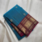 Saturated blue-green Kanchipuram silk body scattered with traditional classic-gold zari buttas.