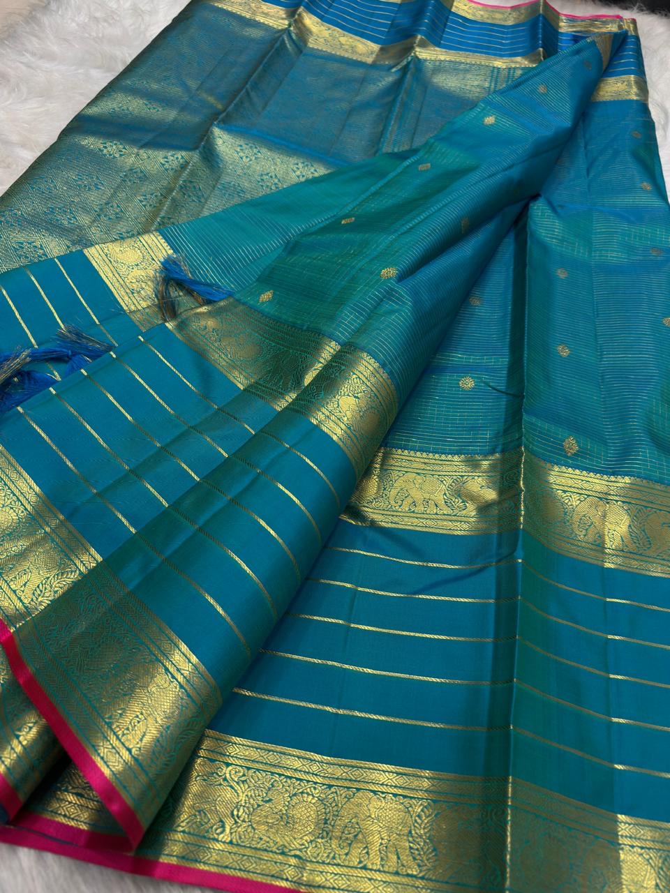 Teal-blue Zari Kattam body with individually spaced classic-gold zari buttas across the checked field.