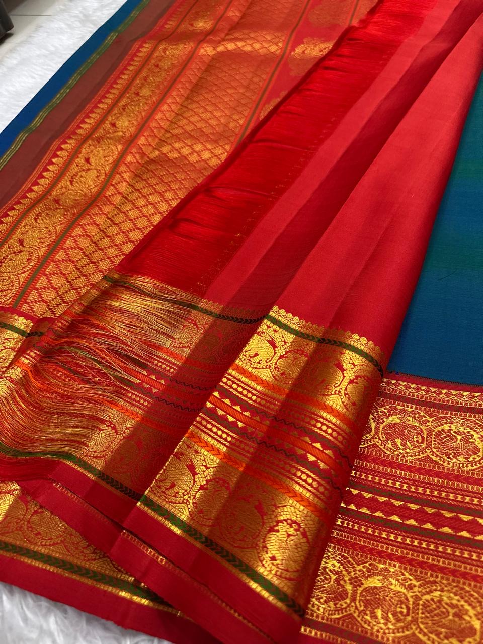 Close-up of shot colour peacock blue-green with blue dominance silk body with gold zari Mayil Chakram circular butta motifs