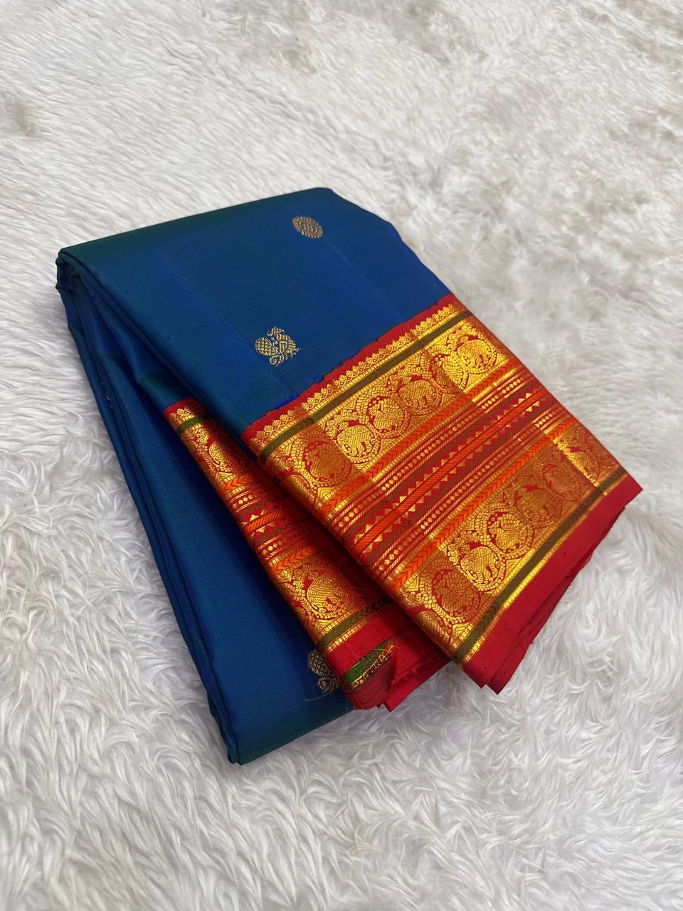 Red pallu with full Sorgavaasal and Yaanai zari procession cascading across width