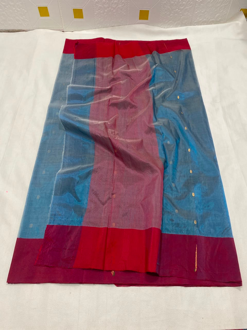 Teal Blue handloom Chanderi saree showing metallic buttas and broad Raspberry Pink contrast border with gold accents.