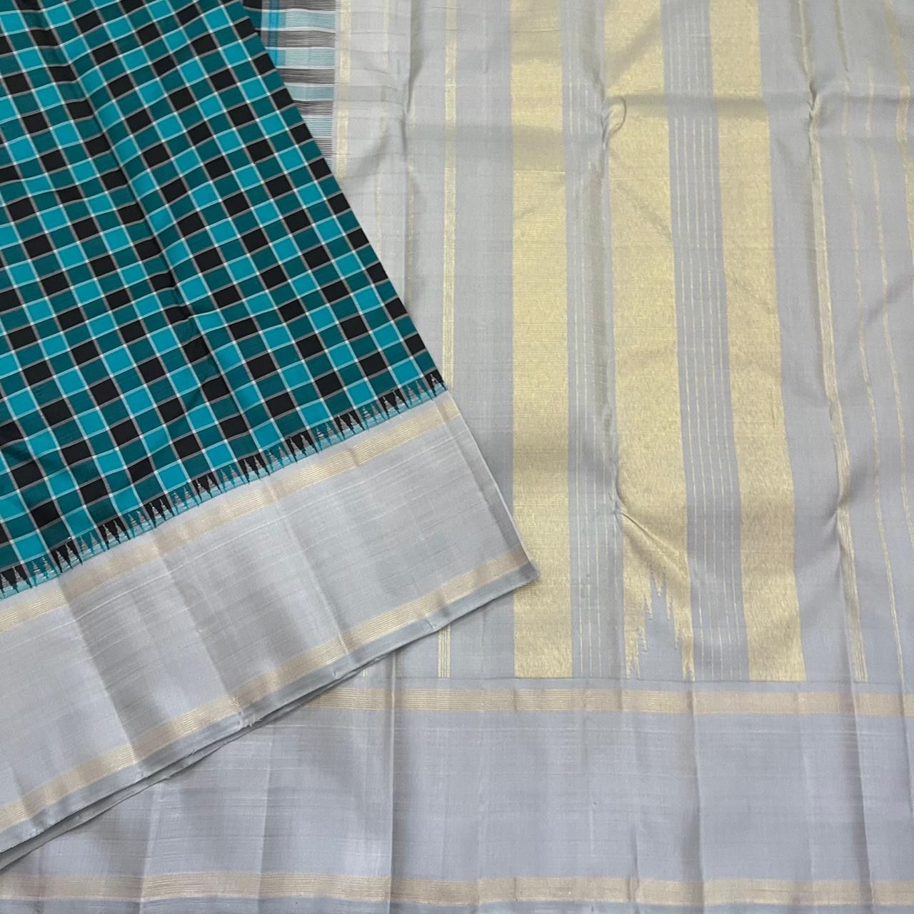 Angled drape of teal checked Pure Kanchipuram silk saree with striped transition and wide silver grey border