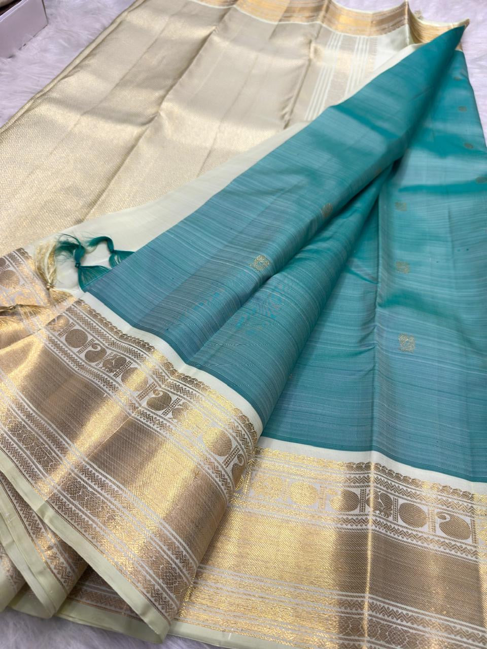 Traditional framed gold zari motifs on ivory Kanchipuram Korvai border