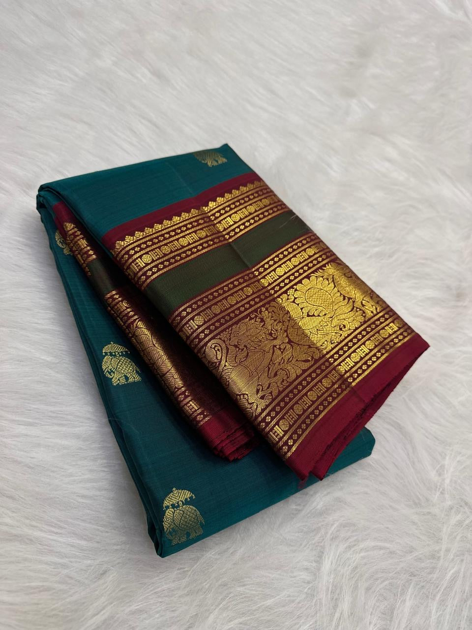 Mayil Kazhuthu teal Kanchipuram silk saree shown beside its saturated Arakku red pallu