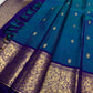 Full view of teal and royal blue pure silk Kanchipuram saree with gandaberunda butta on banana leaf — Idam Living
