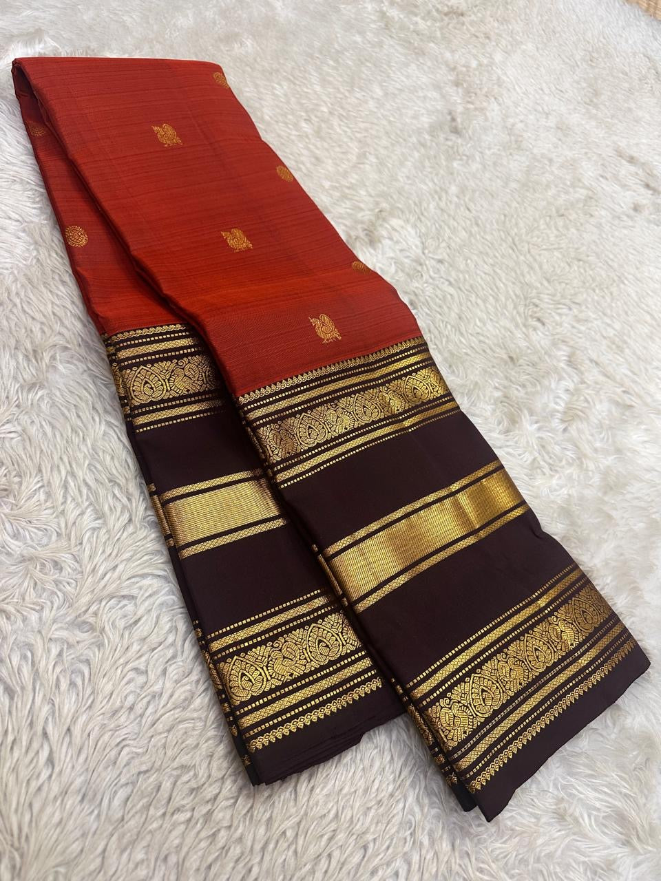 Maanga-inspired gold zari ornament on the Kaapi Kottai brown Varisaipet border of the Terracotta Orange-Red Kanchipuram saree