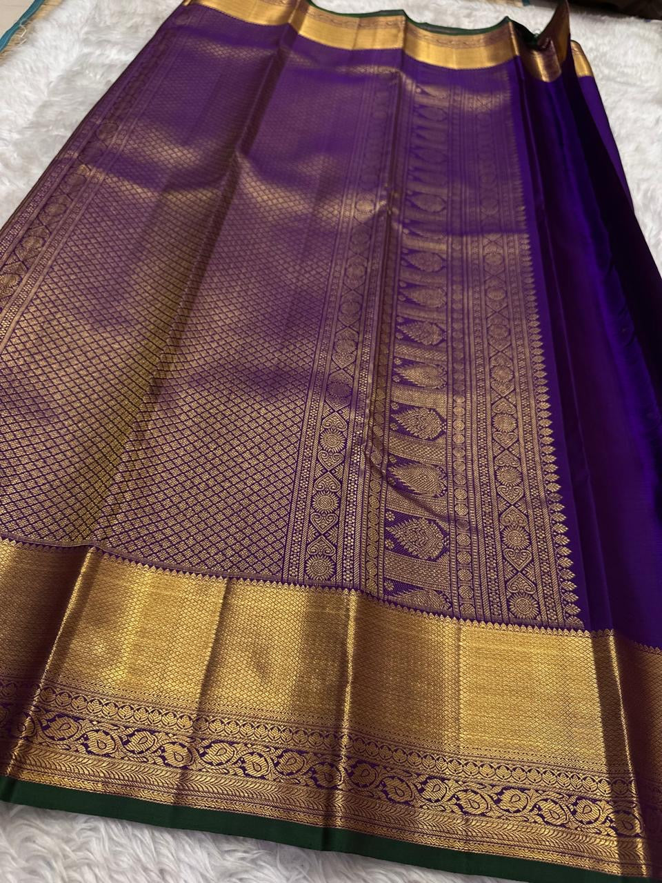 Royal Purple Kanjivaram saree showing traditional Thazhampoo Reku buttas across the silk body.