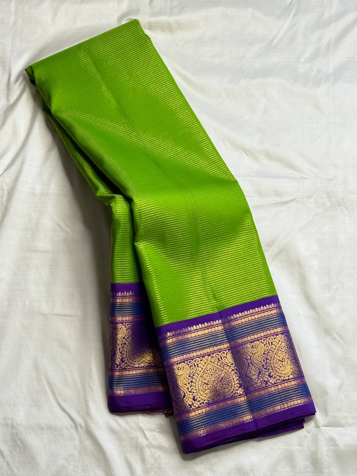 Royal violet zari border on the Thulir Pachai green Kanchipuram Vairaoosi saree