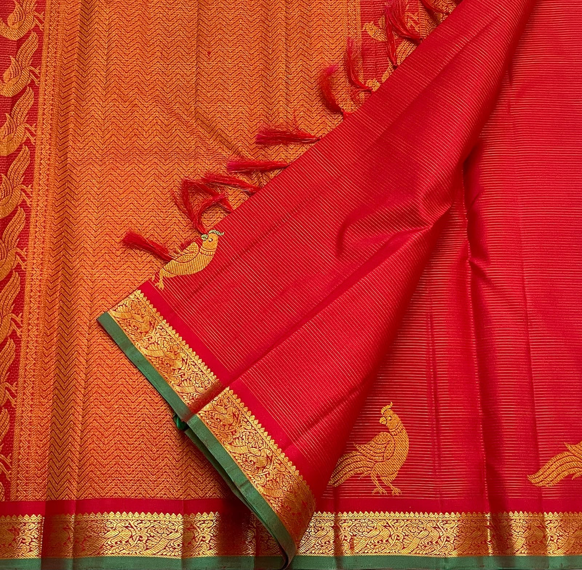 Bright vermilion red Kanchipuram silk saree showing closely spaced Vairaoosi zari lines and gold Kili parrots