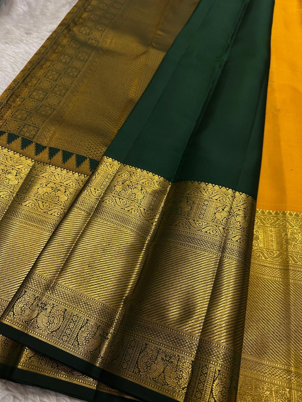 Full pallu spread showing all-over zari woven gold design with dark green frame on a Pure Kanchipuram silk saree.